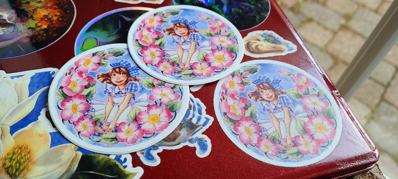 A vinyl sticker depicting a girl in a gingham dress surrounded by a ring of roses.