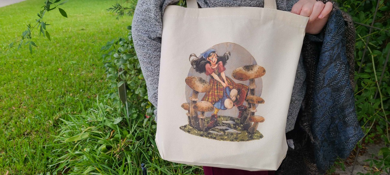 A natural cotton tote bag featuring a Renn Faire or fantasy inspired girl running through oversized mushrooms.  She wears a kerchief and a plaid skirt, and her hair is floating behind her.